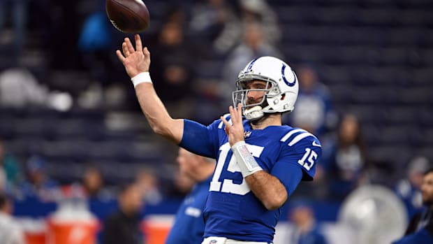 Former Colts QB Joe Flacco (blue jersey) throws a football during warmups.