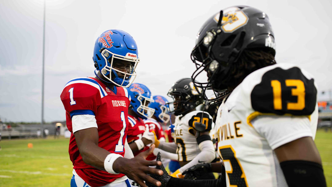 Noxubee County Tigers quarterback Kamario Taylor (1) greets the Starkville high captains before the two teams kicked off the 2024 MHSAA football season on Friday, Aug. 30 in Macon, Miss.