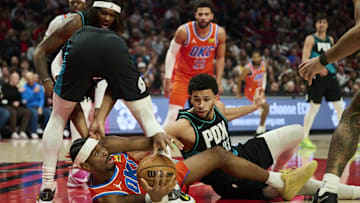 Nov 30, 2025; Portland, Oregon, USA; Oklahoma City Thunder guard Shai Gilgeous-Alexander (2) scrambles to control the ball during the second half against Portland Trail Blazers guard Shaedon Sharpe (17) and forward Toumani Camara (33) at Moda Center. Mandatory Credit: Troy Wayrynen-Imagn Images