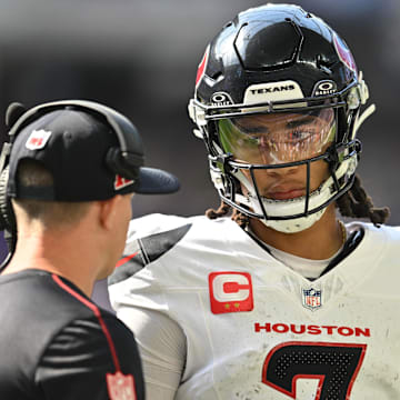 Sep 22, 2024; Minneapolis, Minnesota, USA; Houston Texans quarterback C.J. Stroud (7) talks with an assistant coach during the second quarter against the Minnesota Vikings at U.S. Bank Stadium. Mandatory Credit: Jeffrey Becker-Imagn Images