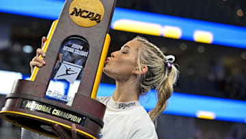 LSU Tigers gymnast Olivia Dunne kisses the trophy after the LSU Tigers gymnastics team wins the national championship.