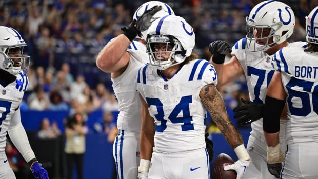 Indianapolis Colts running back Zavier Scott (all-white uniform) celebrates with his teammates after scoring a touchdown. 