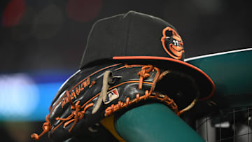 May 8, 2024; Washington, District of Columbia, USA; A Baltimore Orioles hat and glove rest on the dugout rail during a game against the Washington Nationals at Nationals Park. 