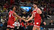 Mar 16, 2025; Indianapolis, IN, USA; Wisconsin Badgers guard Kamari McGee (4) and forward Carter Gilmore (7) high-five during the second half during the 2025 Big Ten Championship Game at Gainbridge Fieldhouse. Mandatory Credit: Robert Goddin-Imagn Images