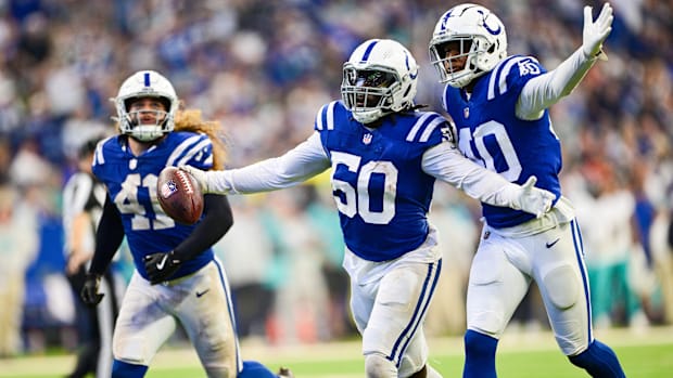 Colts linebacker Segun Olubi (blue jersey) celebrates with teammates after recovering a fumble.