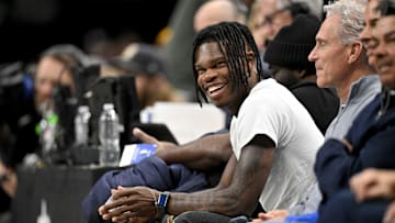 Jan 22, 2025; Dallas, Texas, USA; 2024 Heisman Trophy winner Travis Hunter Jr. laughs during the second half of the game between the Dallas Mavericks and the Minnesota Timberwolves at the American Airlines Center. Mandatory Credit: Jerome Miron-Imagn Images