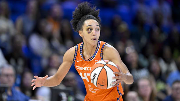 Connecticut Sun guard Leila Lacan dribbles the ball in an orange jersey.