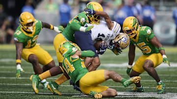 Aug 30, 2025; Eugene, Oregon, USA; Oregon Ducks linebacker Kamar Mothudi (33) and defensive back Zach Grisham (24) tackle Montana State Bobcats wide receiver Jabez Woods (10) during the second half at Autzen Stadium. Mandatory Credit: Troy Wayrynen-Imagn Images