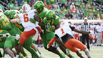 Sep 6, 2025; Eugene, Oregon, USA; Oregon Ducks running back Jordon Davison (0) scores a touchdown during the second half against Oklahoma State Cowboys cornerback JK Johnson (1) at Autzen Stadium. Mandatory Credit: Troy Wayrynen-Imagn Images