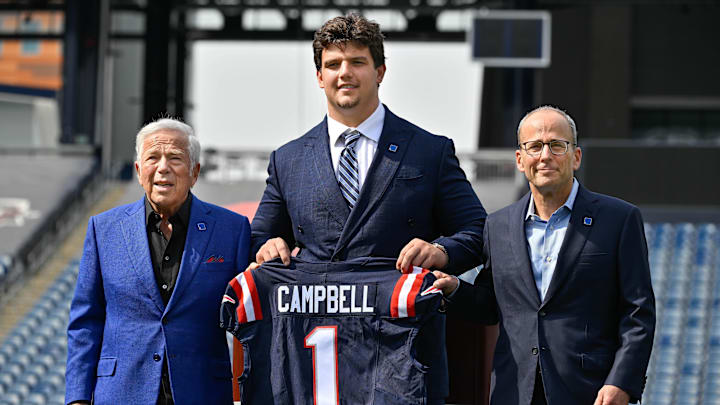 Apr 25, 2025; Foxborough, MA, USA; New England Patriots first round draft pick Will Campbell is presented with a ceremonial first round jersey by team owner Robert Kraft (l) and team president Jonathan Kraft (r) at a press conference on the game field at Gillette Stadium. Mandatory Credit: Eric Canha-Imagn Images Apr 25, 2025; Foxborough, MA, USA; New England Patriots first round draft pick Will Campbell is presented with a ceremonial first round jersey by team owner Robert Kraft (l) and team president Jonathan Kraft (r) at a press conference on the game field at Gillette Stadium. Mandatory Credit: Eric Canha-Imagn Images