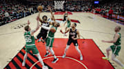 Mar 23, 2025; Portland, Oregon, USA; Portland Trail Blazers guard Scoot Henderson (00) drives to the basket during the second half against Boston Celtics center Al Horford (42) and forward Baylor Scheierman (55) at Moda Center. Mandatory Credit: Troy Wayrynen-Imagn Images