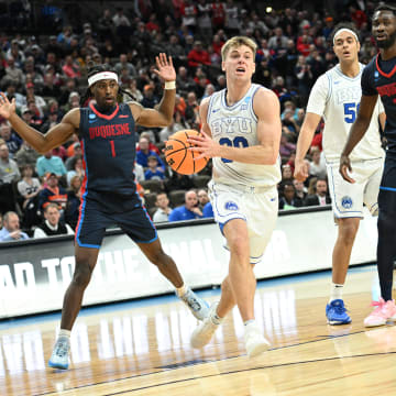 Mar 21, 2024; Omaha, NE, USA; Brigham Young Cougars guard Dallin Hall (30) drives past Duquesne Dukes forward David Dixon (2) in the second half during the first round of the NCAA Tournament at CHI Health Center Omaha. Mandatory Credit: Steven Branscombe-USA TODAY Sports