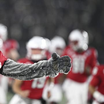 Dec 28, 2024; Annapolis, MD, USA;  North Carolina State Wolfpack mascot Mr. Wolf runs ion the field with the team before the start of the Go Bowling Military Bowl against the East Carolina Pirates  at Navy-Marine Corps Memorial Stadium. Mandatory Credit: Tommy Gilligan-Imagn Images