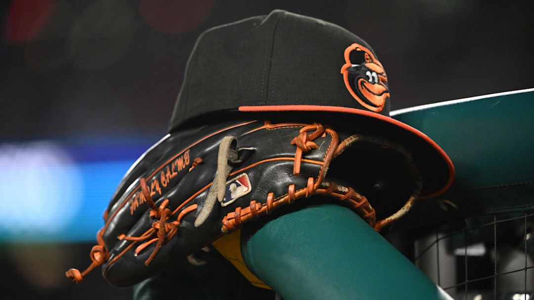 May 8, 2024; Washington, District of Columbia, USA; A Baltimore Orioles hat and glove rest on the dugout rail during a game against the Washington Nationals at Nationals Park. Mandatory Credit: Rafael Suanes-Imagn Images
