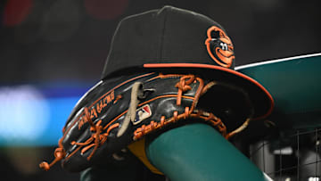 May 8, 2024; Washington, District of Columbia, USA; A Baltimore Orioles hat and glove rest on the dugout rail during a game against the Washington Nationals at Nationals Park. Mandatory Credit: Rafael Suanes-Imagn Images