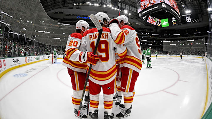 Apr 7, 2026; Dallas, Texas, USA; Calgary Flames defenseman Zayne Parekh (19) and left wing Blake Coleman (20) and right wing Matvei Gridin (92) celebrates after Parekh scores a power-play goal against the Dallas Stars during the third period at the American Airlines Center. Mandatory Credit: Jerome Miron-Imagn Images