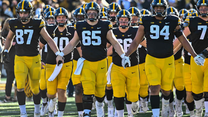 Nov 18, 2023; Iowa City, Iowa, USA; Iowa Hawkeyes tight end Addison Ostrenga (87) and quarterback Deacon Hill (10) and offensive lineman Logan Jones (65) and defensive lineman Yahya Black (94) come onto the field during the Iowa Swarm before the game against the Illinois Fighting Illini at Kinnick Stadium. Mandatory Credit: Jeffrey Becker-USA TODAY Sports