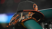 May 8, 2024; Washington, District of Columbia, USA; A Baltimore Orioles hat and glove rest on the dugout rail during a game against the Washington Nationals at Nationals Park. Mandatory Credit: Rafael Suanes-Imagn Images