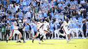 Oct 25, 2025; Chapel Hill, North Carolina, USA;  Virginia Cavaliers players celebrate after stopping North Carolina Tar Heels short of the goal line on a two point try to win in overtime at Kenan Stadium. Mandatory Credit: Bob Donnan-Imagn Images