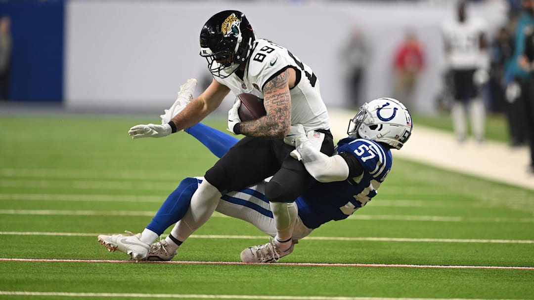 Jan 5, 2025; Indianapolis, Indiana, USA; Jacksonville Jaguars tight end Luke Farrell (89) is tackled by Indianapolis Colts linebacker Jaylon Carlies (57) during the first quarter at Lucas Oil Stadium. 