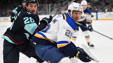 Apr 12, 2025; Seattle, Washington, USA; Seattle Kraken center Ryan Winterton (26) and St. Louis Blues right wing Jordan Kyrou (25) during the third period at Climate Pledge Arena. Mandatory Credit: Steven Bisig-Imagn Images