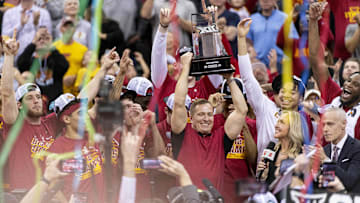 Mar 16, 2024; Kansas City, MO, USA; Streamers fall as Iowa State Cyclones head coach TJ Otzelberger hoists the Big 12 Tournament trophy alongside his team after defeating the Houston Cougars at T-Mobile Center. Mandatory Credit: Amy Kontras-Imagn Images