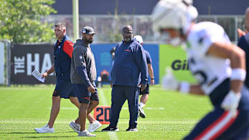 Jul 28, 2025; Foxborough, MA, USA; New England Patriots head coach Mike Vrabel (red sleeves and defensive coordinator Terrell Williams (blue pants) watch the team during training camp at Gillette Stadium. Mandatory Credit: Eric Canha-Imagn Images