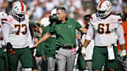 Nov 1, 2025; Dallas, Texas, USA;  Miami Hurricanes head coach Mario Cristobal talks to offensive lineman Anez Cooper (73) and offensive lineman Francis Mauigoa (61) during the second half against the SMU Mustangs at Gerald J. Ford Stadium. Mandatory Credit: Jerome Miron-Imagn Images