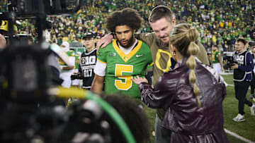 Nov 14, 2025; Eugene, Oregon, USA; Oregon Ducks quarterback Dante Moore (5) and head coach Dan Lanning talk to a reporter after a game against the Minnesota Golden Gophers at Autzen Stadium. Mandatory Credit: Troy Wayrynen-Imagn Images