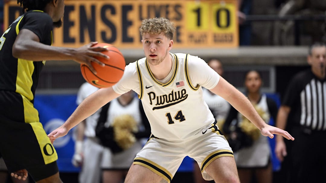 Purdue Boilermakers guard Jack Benter (14) defends against Oregon Ducks guard Takai Simpkins (5).