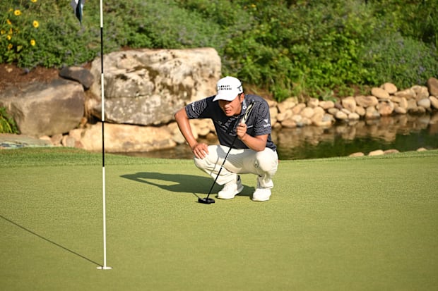 Michael Kim lines is at the head of a putt on the 18th hole 
