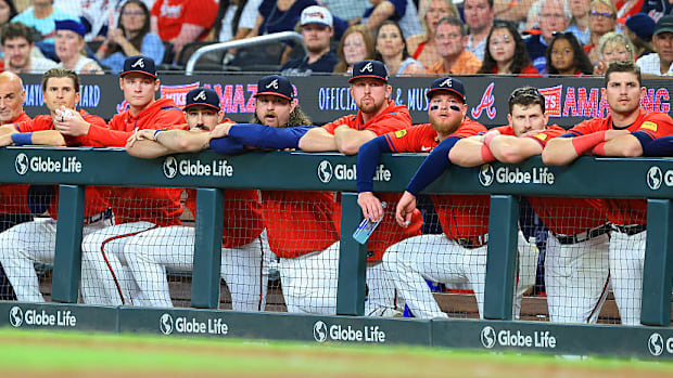 Atlanta Braves watch from the top of the dugout railing