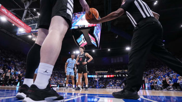 A referee hands off the ball to Cincinnati Bearcats guard Simas Lukosius (41) on Tuesday, March 26,