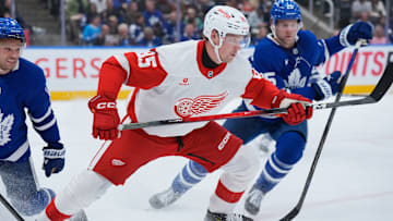 Elmer Soderblom (85) battles multiple members of the Toronto Maple Leafs for the puck. 
