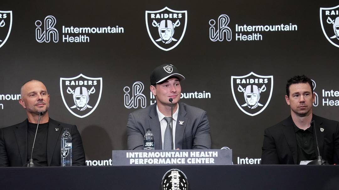 Apr 24, 2026; Henderson, NV, USA; Las Vegas Raiders quarterback Fernando Mendoza (center) speaks at introductory press conference at Intermountain Health Performance Center flanked by general manager John Spytek (left) and head coach Klint Kubiak after being selected as the No. 1 pick in the 2026 NFL Draft. Mandatory Credit: Kirby Lee-Imagn Images