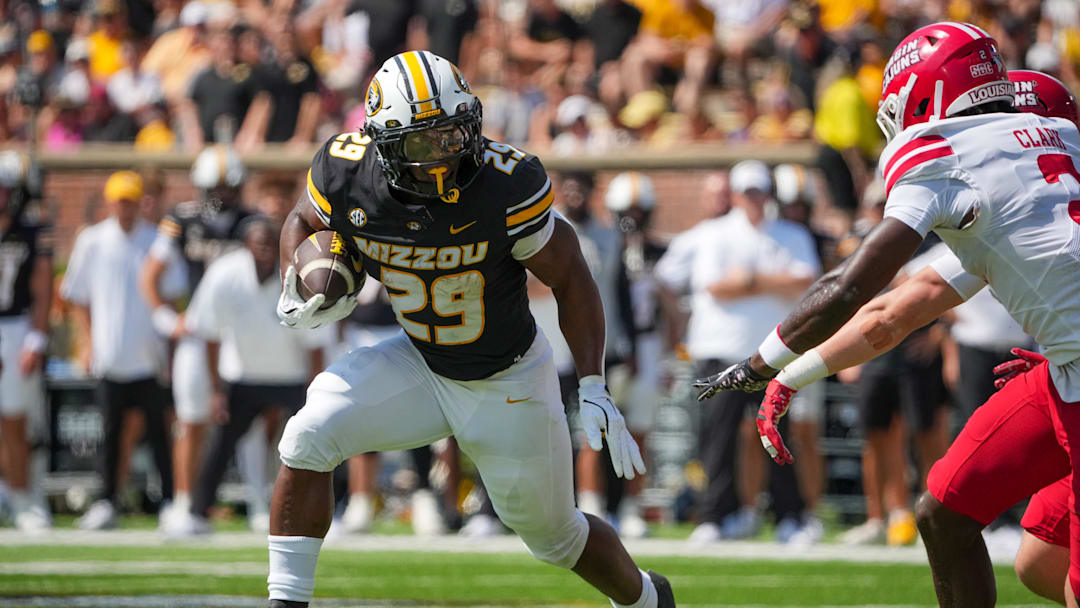 Sep 13, 2025; Columbia, Missouri, USA; Missouri Tigers running back Ahmad Hardy (29) runs the ball as Louisiana-Lafayette Ragin Cajuns safety Jalen Clark (2) defends during the first half of the game at Faurot Field at Memorial Stadium. Mandatory Credit: Denny Medley-Imagn Images