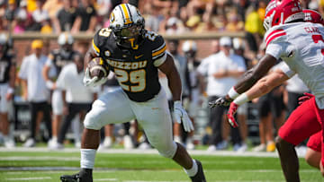 Sep 13, 2025; Columbia, Missouri, USA; Missouri Tigers running back Ahmad Hardy (29) runs the ball as Louisiana-Lafayette Ragin Cajuns safety Jalen Clark (2) defends during the first half of the game at Faurot Field at Memorial Stadium. Mandatory Credit: Denny Medley-Imagn Images
