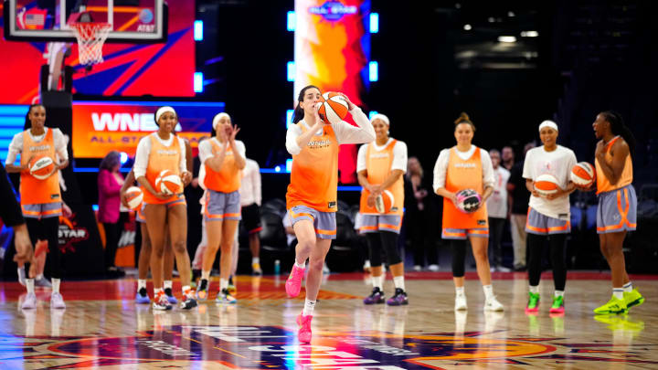 July 19, 2024; Phoenix, Ariz., U.S.; Fever guard Caitlin Clark shoots a half-court shot with her teammates behind her during WNBA All-Star practice on Media Day at the Footprint Center.