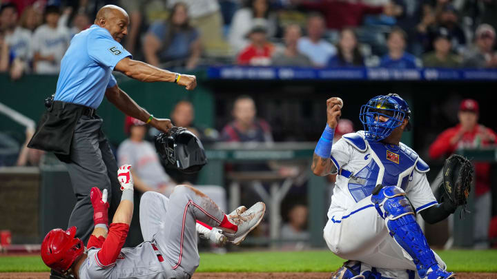 Jun 12, 2023; Kansas City, Missouri, USA; Cincinnati Reds center fielder TJ Friedl (29) is called out at home by umpire CB Bucknor (54) after the tag by Kansas City Royals catcher Salvador Perez (13) during the tenth inning at Kauffman Stadium. The call was overturned and the Reds defeated the Royals in ten innings. Mandatory Credit: Jay Biggerstaff-USA TODAY Sports