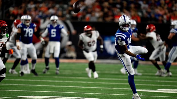 Colts receiver Adonai Mitchell (blue jersey with white helmet/pants) misses a throw from his quarterback over his head. 