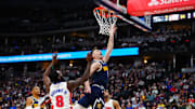 Dec 28, 2024; Denver, Colorado, USA; Denver Nuggets guard Christian Braun (0) shoots the ball past Detroit Pistons forward Tim Hardaway Jr. (8) in the second quarter at Ball Arena. Mandatory Credit: Ron Chenoy-Imagn Images