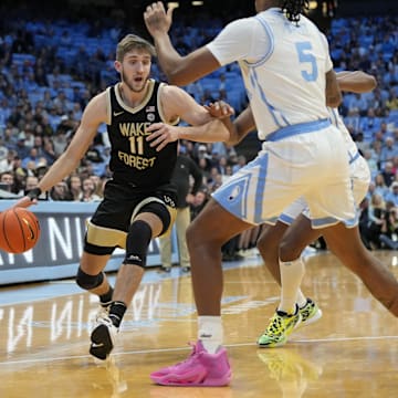 Jan 22, 2024; Chapel Hill, North Carolina, USA;  Wake Forest Demon Deacons forward Andrew Carr (11) dribbles as North Carolina Tar Heels forward Armando Bacot (5) defends in the first half at Dean E. Smith Center. Mandatory Credit: Bob Donnan-Imagn Images