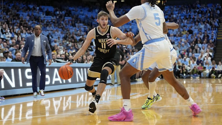 Jan 22, 2024; Chapel Hill, North Carolina, USA;  Wake Forest Demon Deacons forward Andrew Carr (11) dribbles as North Carolina Tar Heels forward Armando Bacot (5) defends in the first half at Dean E. Smith Center. Mandatory Credit: Bob Donnan-Imagn Images