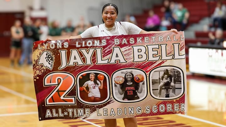 Jayla Bell of Lyons High holds a banner celebrating her 2,000th point and becoming all-time leading scorer at the school, surpassing her brother's record of 1,987 points. Jayla Bell of Lyons High holds a banner celebrating her 2,000th point and becoming all-time leading scorer at the school, surpassing her brother's record of 1,987 points.