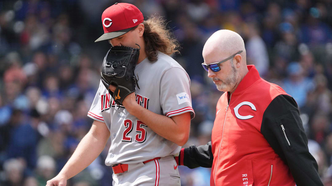 May 7, 2026; Chicago, Illinois, USA; Cincinnati Reds pitcher Rhett Lowder (25) leaves the game against the Chicago Cubs with the team trainer during the fourth inning at Wrigley Field. Mandatory Credit: David Banks-Imagn Images