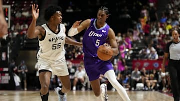 Jul 14, 2025; Las Vegas, NV, USA;  Utah Jazz forward Cody Williams (5) drives the ball against San Antonio Spurs guard Harrison Ingram (55) during the first half of a NBA basketball game at the Thomas & Mack Center. Mandatory Credit: Lucas Peltier-Imagn Images