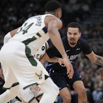 Mar 8, 2025; Milwaukee, Wisconsin, USA; Orlando Magic guard Cole Anthony (50) drives against Milwaukee Bucks guard AJ Green (20) and forward Giannis Antetokounmpo (34) in the second half at Fiserv Forum. Mandatory Credit: Michael McLoone-Imagn Images