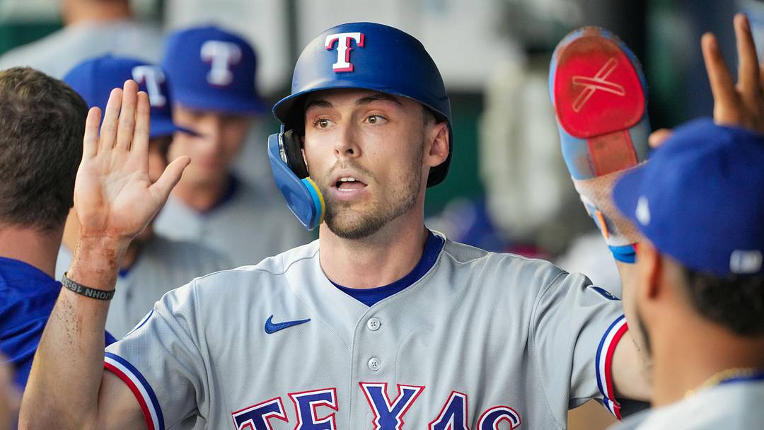 Jun 9, 2026; Kansas City, Missouri, USA; Texas Rangers center fielder Evan Carter (32) celebrates in the dugout against the Kansas City Royals after scoring in the fourth inning at Kauffman Stadium. Mandatory Credit: Denny Medley-Imagn Images
