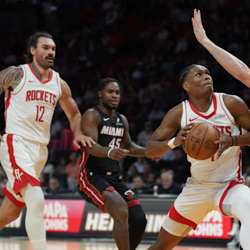 Mar 21, 2025; Miami, Florida, USA;  Houston Rockets forward Amen Thompson (1) drives to the basket as Miami Heat forward Kevin Love (42) defends at Kaseya Center. Mandatory Credit: Jim Rassol-Imagn Images