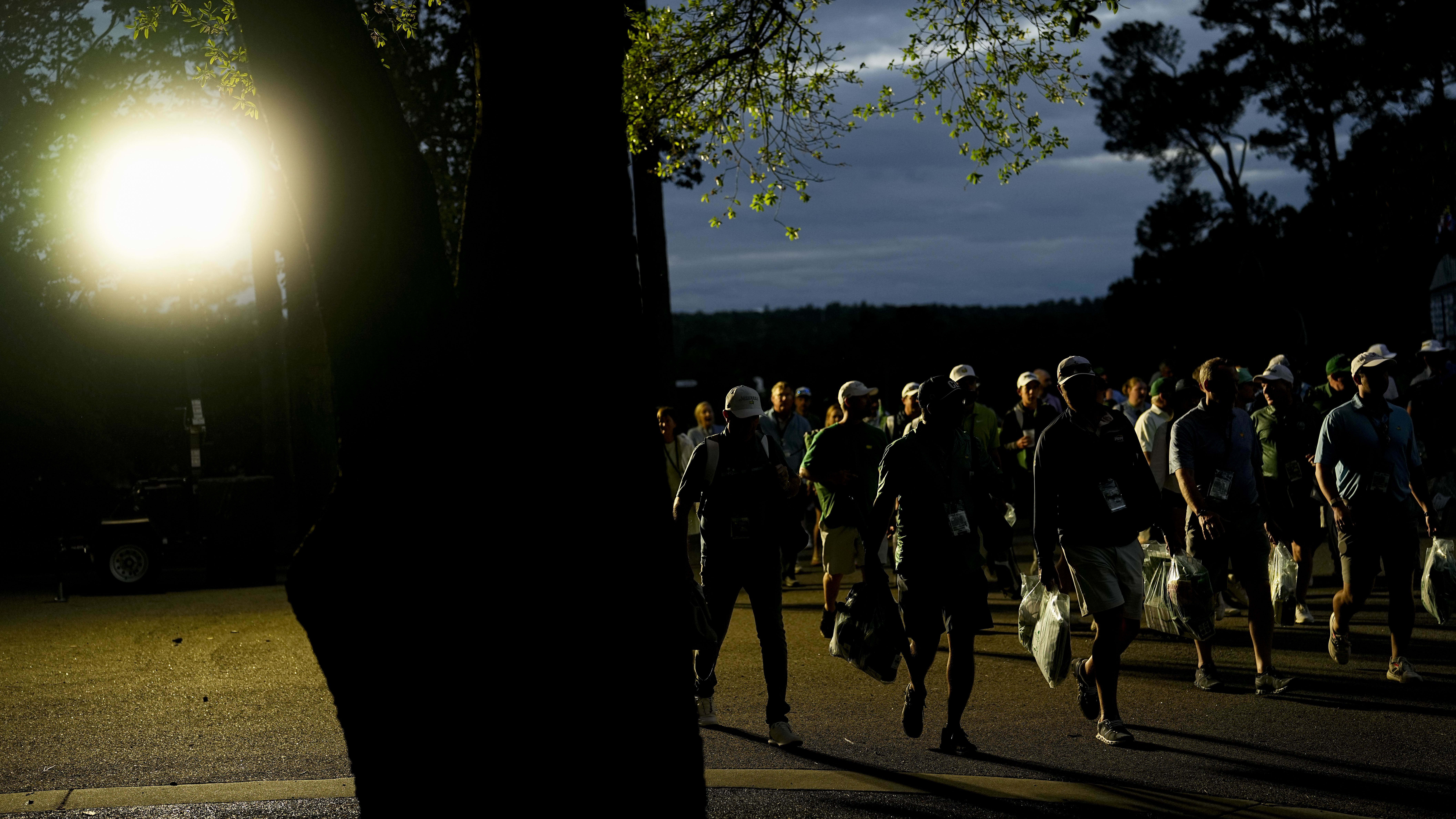 Patrons leave the course after play was stopped as the sun set in Round 1 at the 2024 Masters,